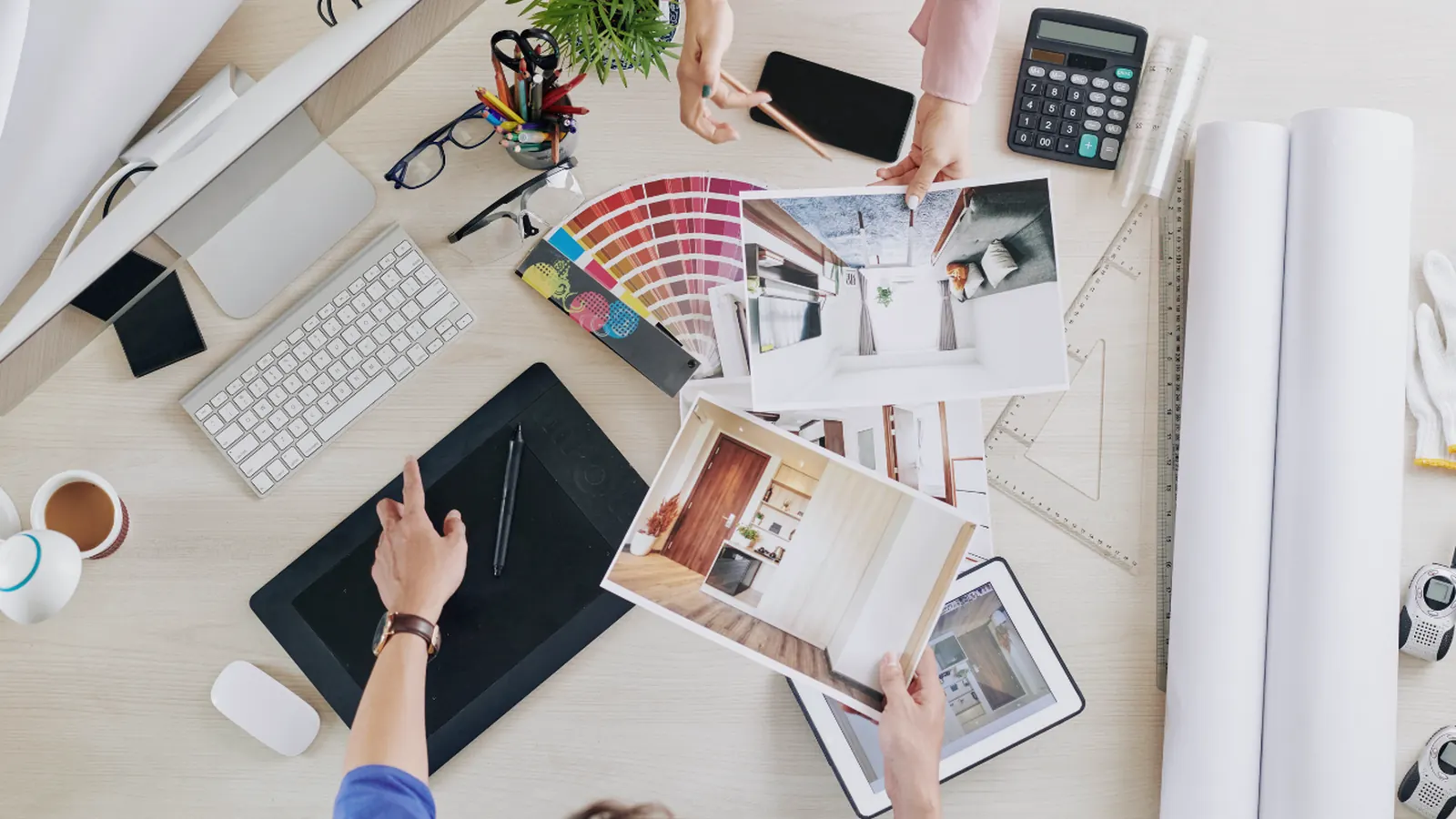 Bureau d'architecte vu de haut, avec un nuancier, des plans et une tablette graphique