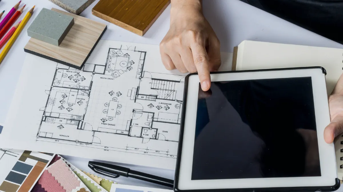 Plan d'un logement et tablette sur un bureau